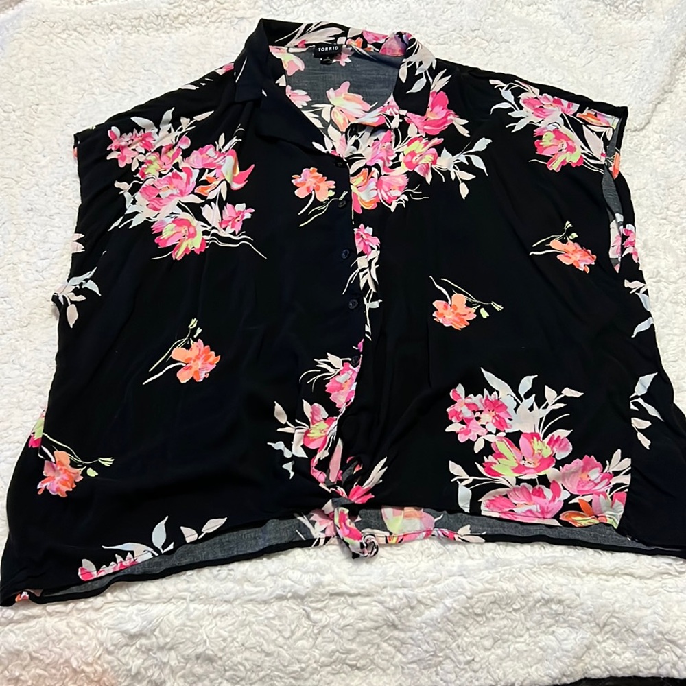 Top de botones y amarrada al frente negra y flores rosas